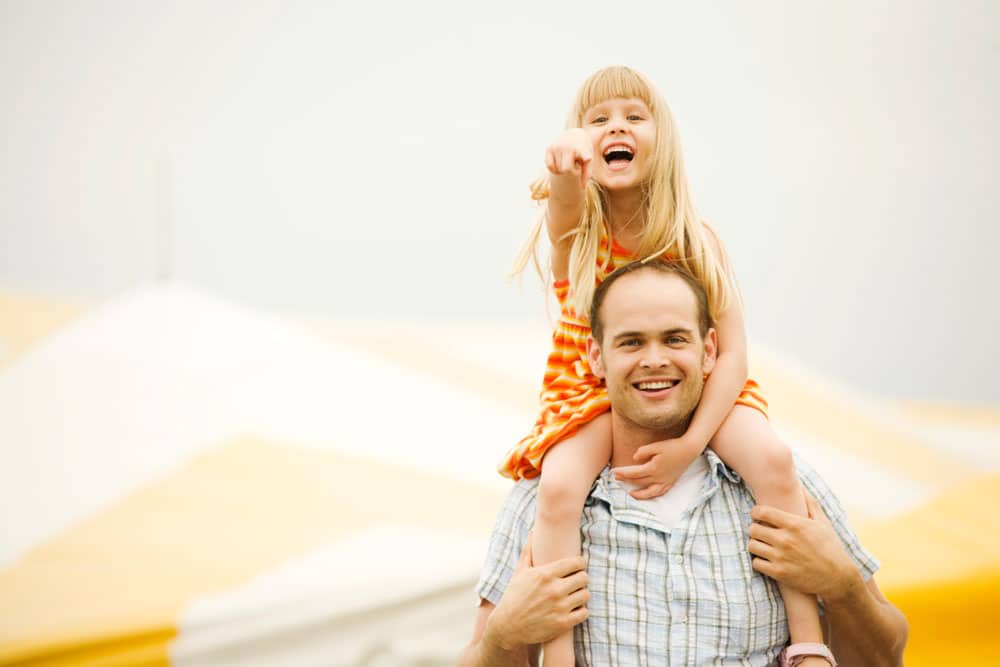 Father carrying his daughter on his shoulder