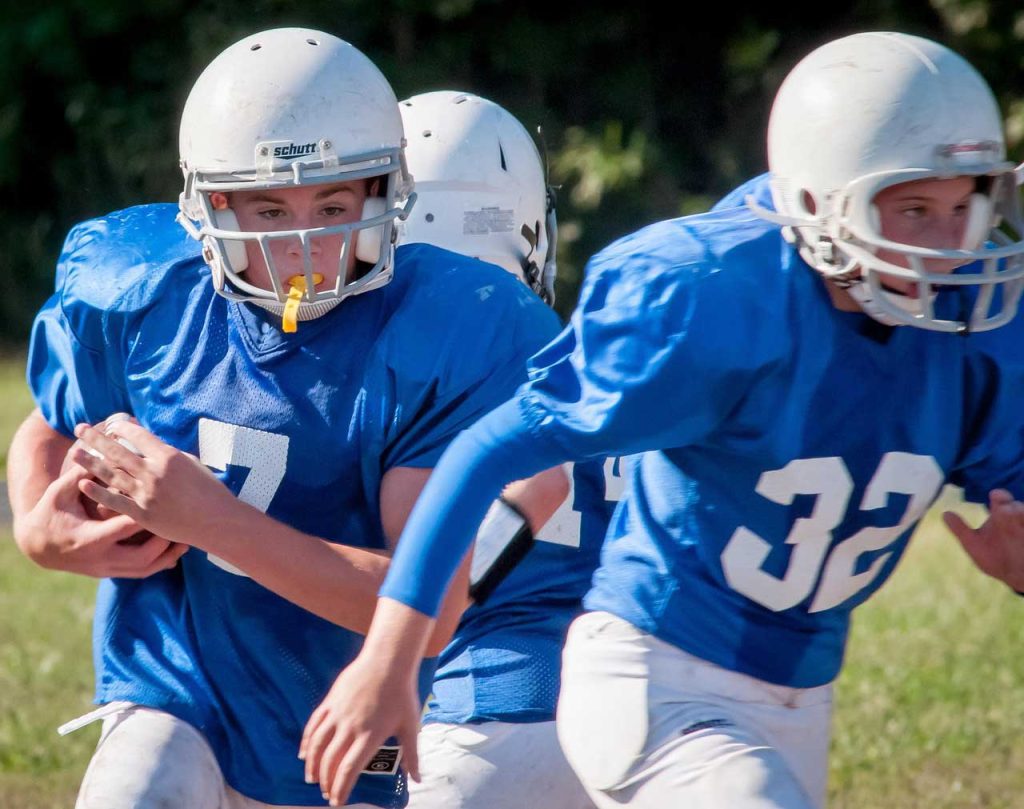 Young football players wearing custom mouthguards.